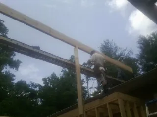 Carpenter setting a ridge beam over a new addition frame — Ice Dam Removal by Roofing Brothers in Cromwell
