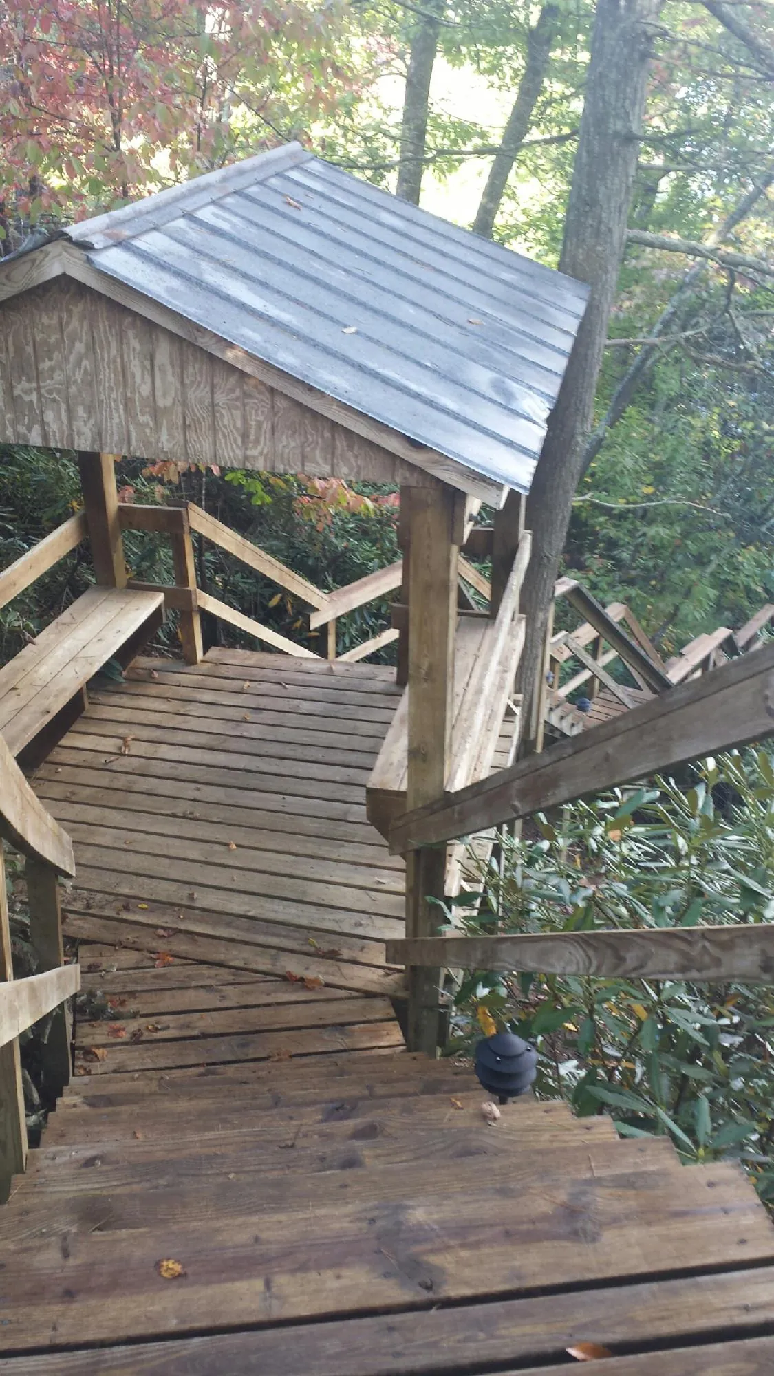 Metal roofed shelter over wooden steps on a wooded walkway — Skylight Repair & Installation work by our crew in Cromwell